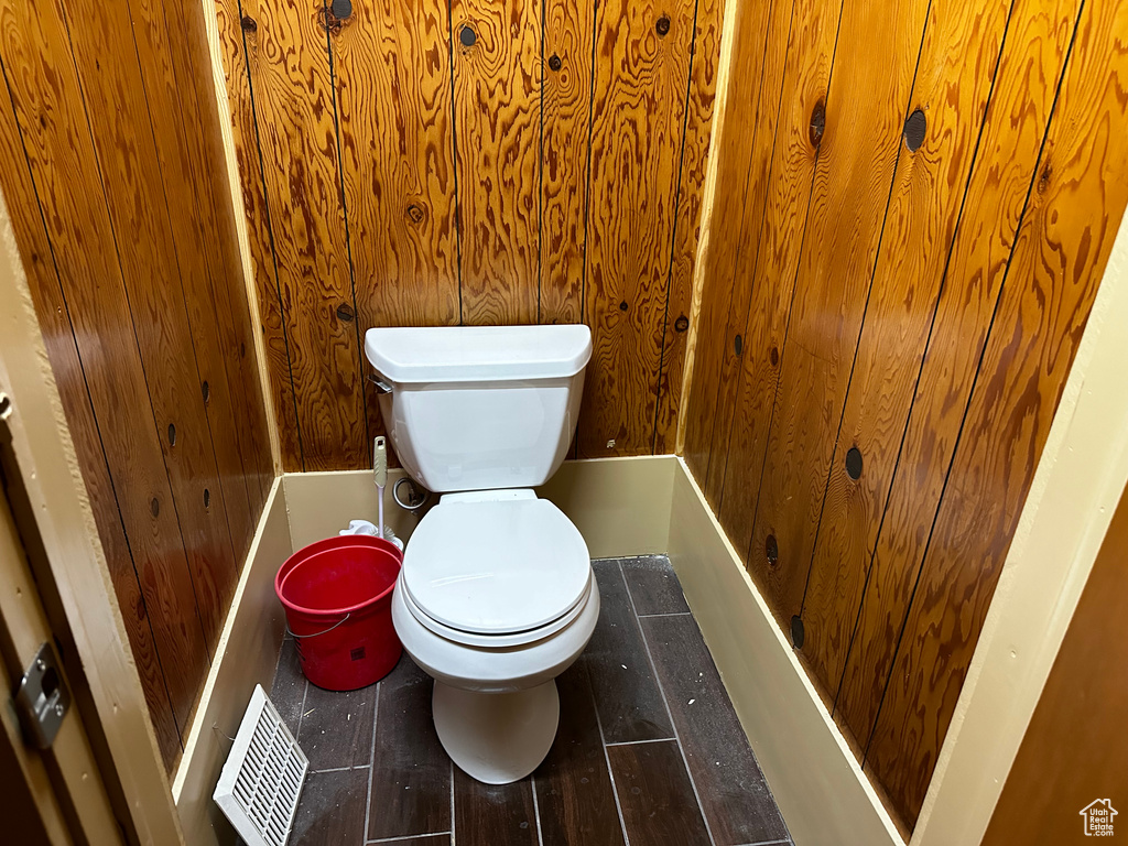 Bathroom featuring wooden walls and toilet