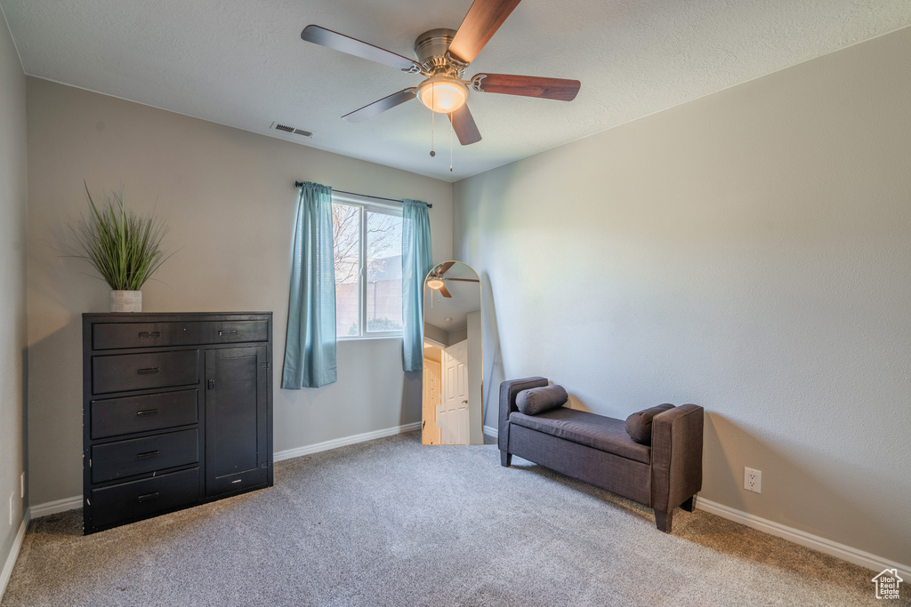Sitting room featuring ceiling fan and light carpet