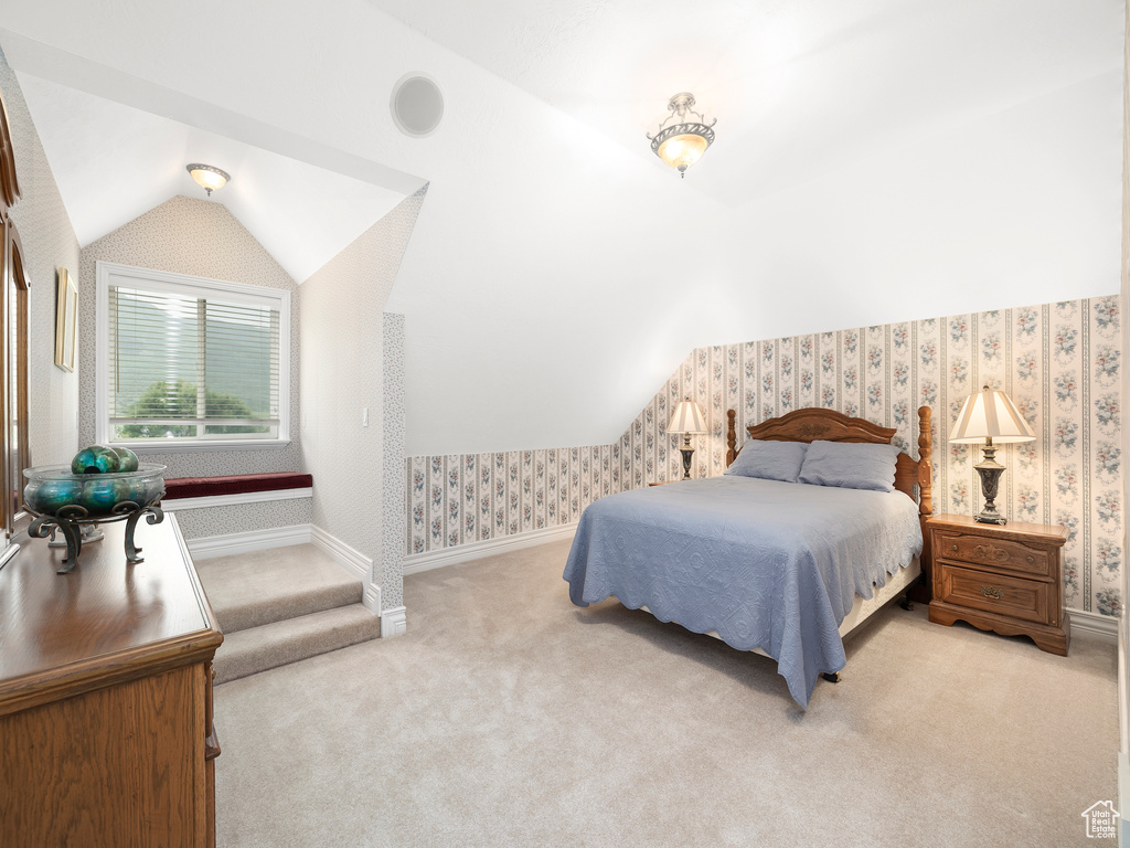 Bedroom with vaulted ceiling and light colored carpet