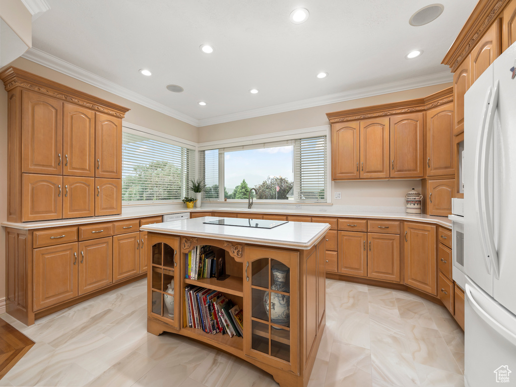 Kitchen with white appliances, crown molding, sink, light tile floors, and a center island
