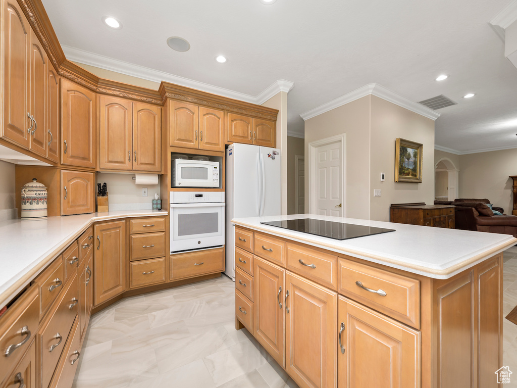 Kitchen featuring white appliances, a center island, light tile flooring, and ornamental molding