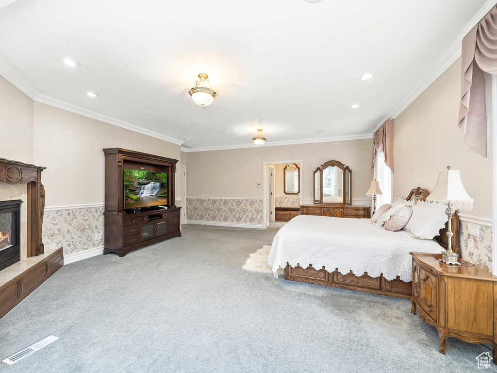 Carpeted bedroom featuring ornamental molding and a tile fireplace