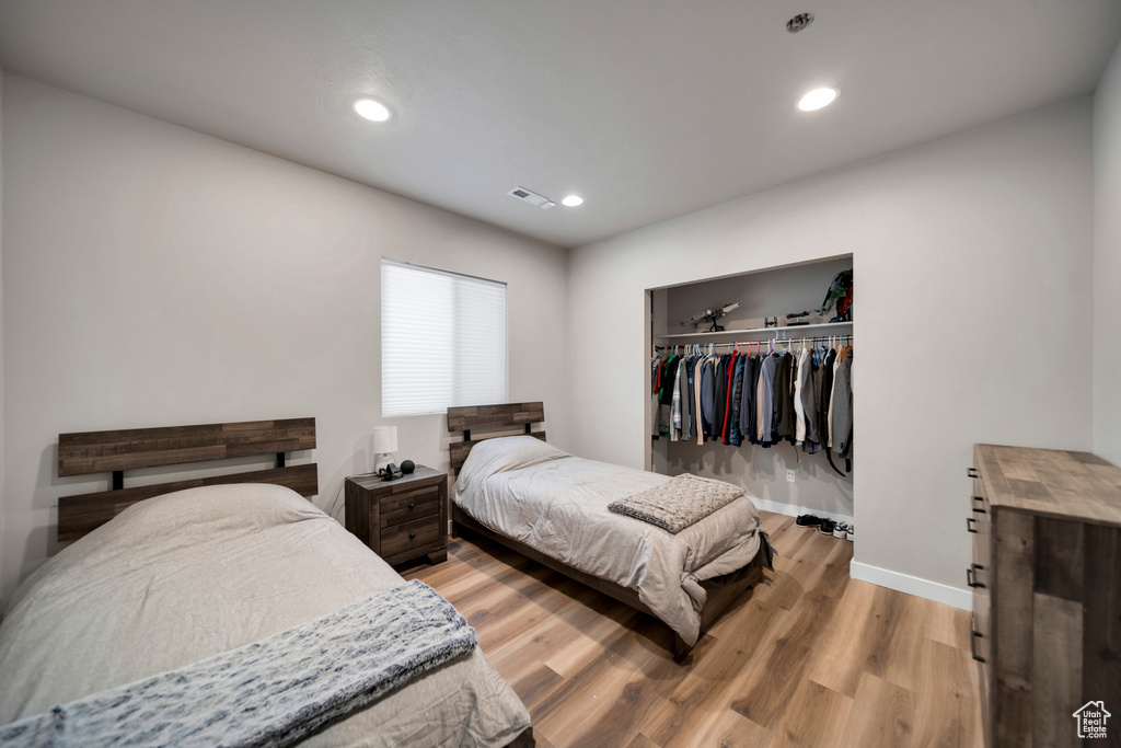 Bedroom with a closet and light hardwood / wood-style flooring