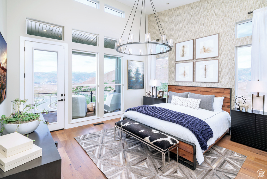 Bedroom featuring french doors, a chandelier, light hardwood / wood-style flooring, and access to exterior
