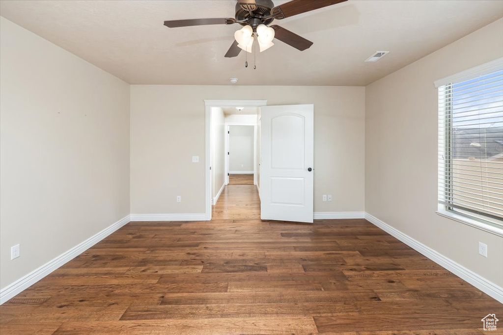 Unfurnished room with dark hardwood / wood-style floors and ceiling fan