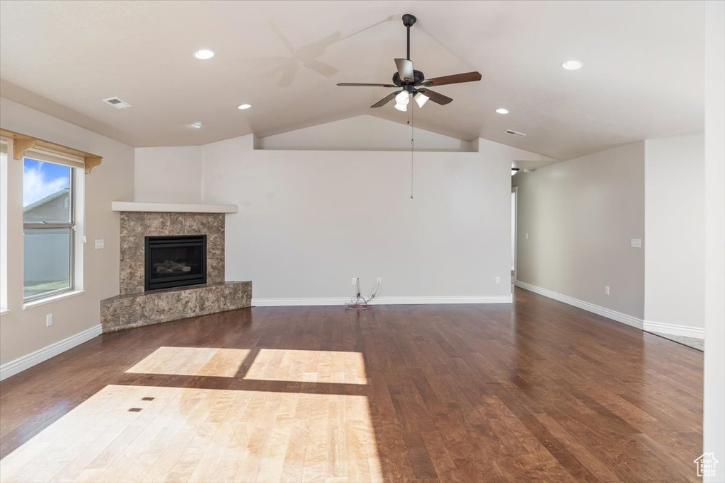 Unfurnished living room with dark hardwood / wood-style flooring, lofted ceiling, and ceiling fan