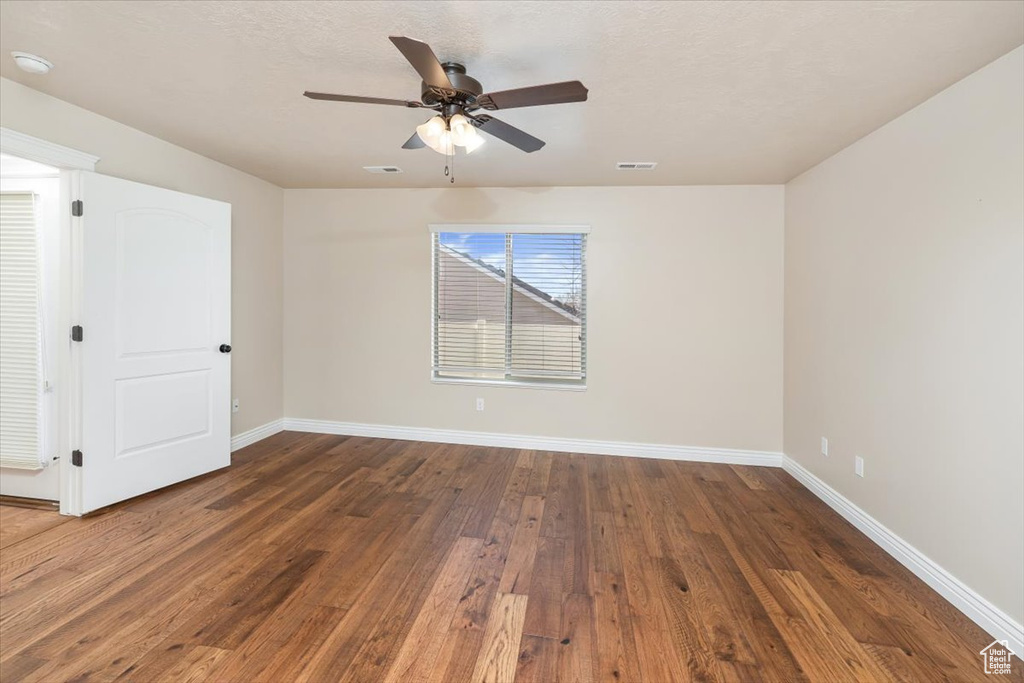 Spare room with dark hardwood / wood-style floors and ceiling fan
