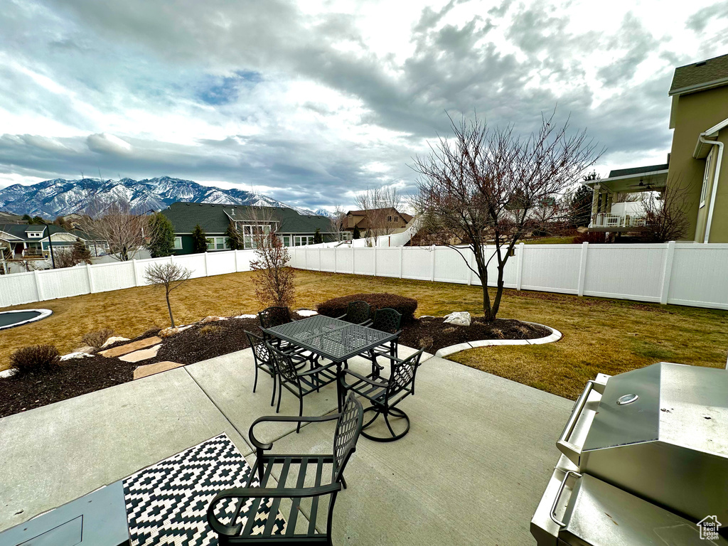View of patio with a mountain view and area for grilling