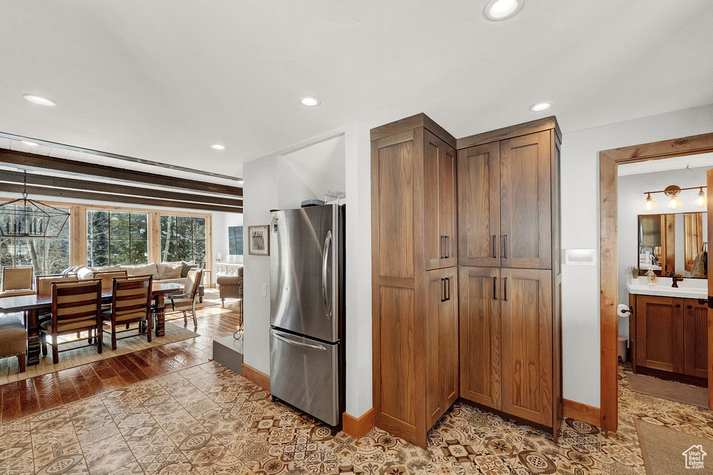 Kitchen with stainless steel refrigerator, an inviting chandelier, decorative light fixtures, light hardwood / wood-style flooring, and sink
