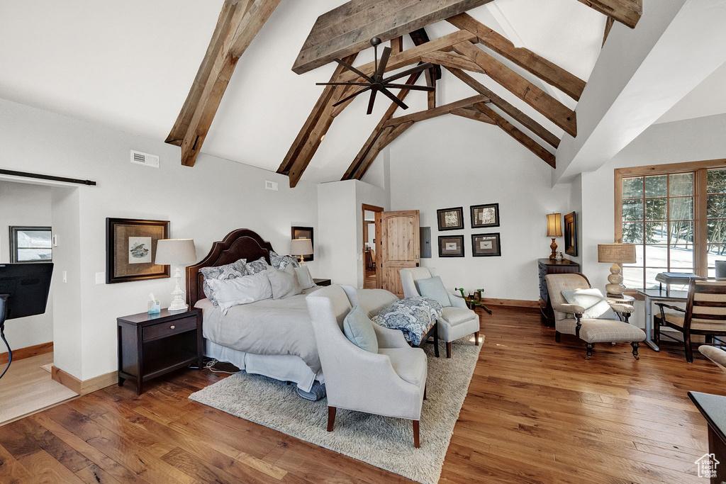Bedroom featuring dark wood-type flooring, high vaulted ceiling, and beam ceiling