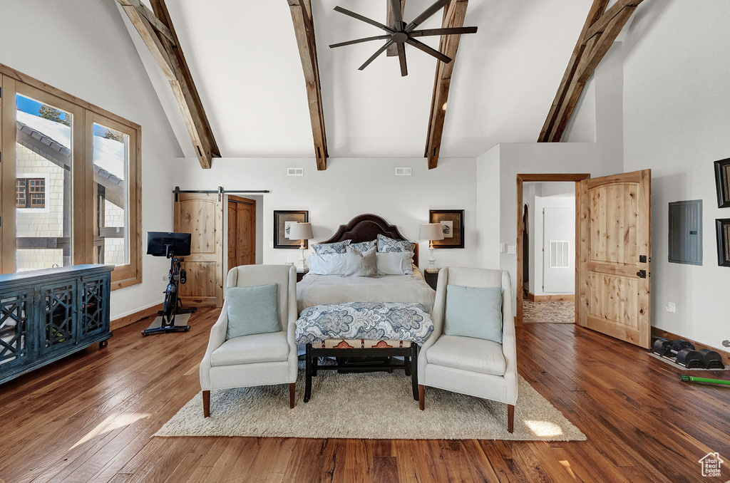 Bedroom with beam ceiling, a barn door, high vaulted ceiling, and dark wood-type flooring