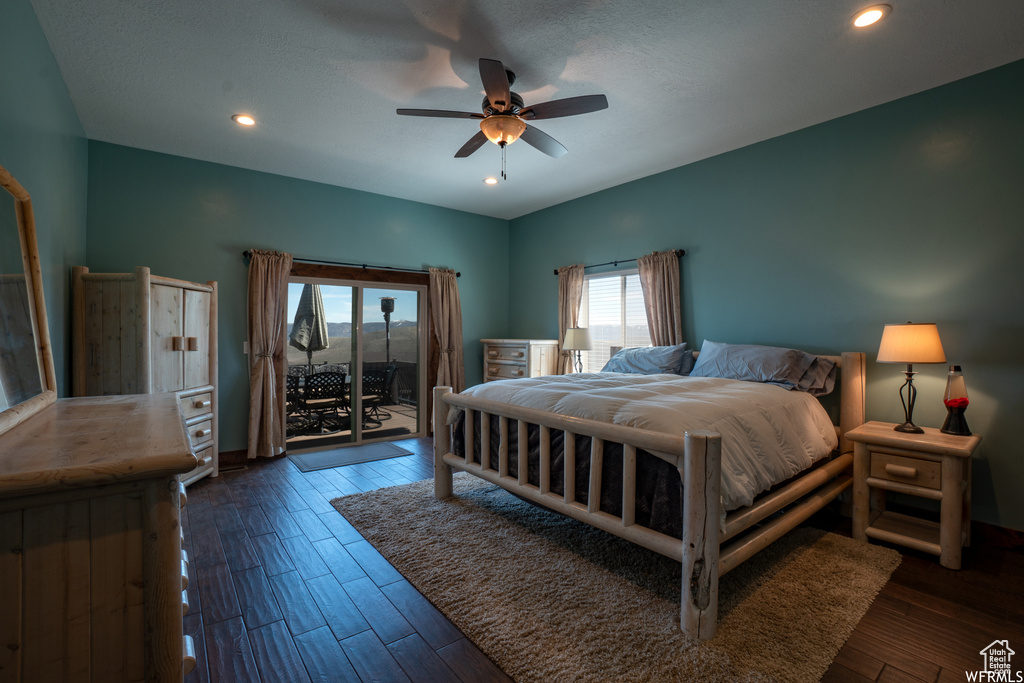 Bedroom featuring dark hardwood / wood-style flooring, ceiling fan, and access to outside