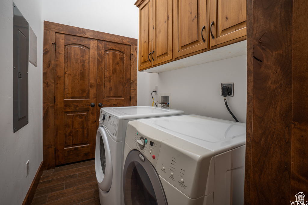 Laundry room featuring dark hardwood / wood-style flooring, electric dryer hookup, washing machine and dryer, hookup for a washing machine, and cabinets