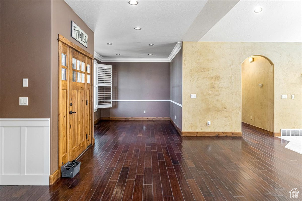 Interior space with ornamental molding and hardwood / wood-style flooring