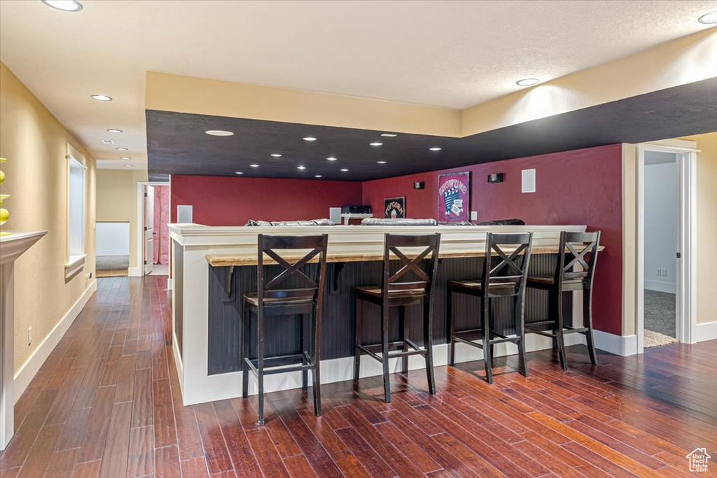 Kitchen featuring a kitchen breakfast bar, kitchen peninsula, and dark wood-type flooring