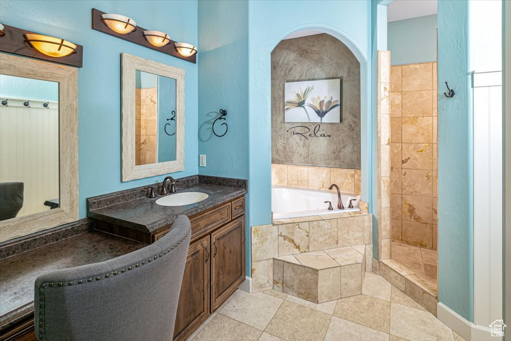 Bathroom featuring plus walk in shower, tile floors, and large vanity