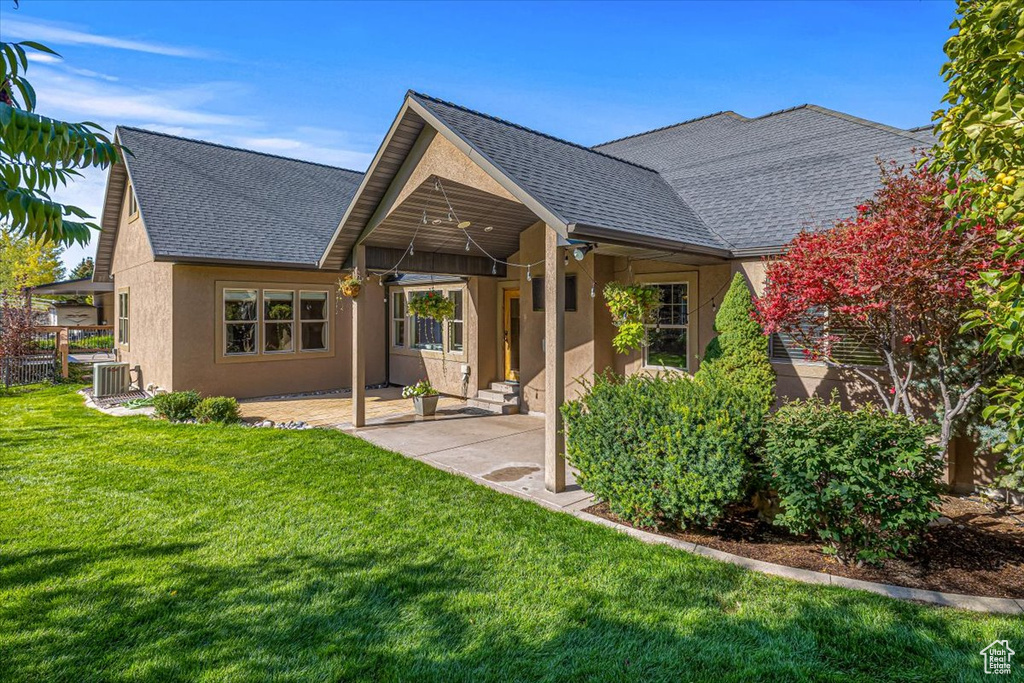 Rear view of property featuring ceiling fan, a lawn, a patio area, and central air condition unit