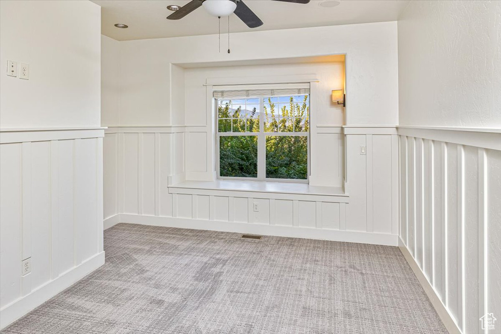 Carpeted spare room featuring ceiling fan