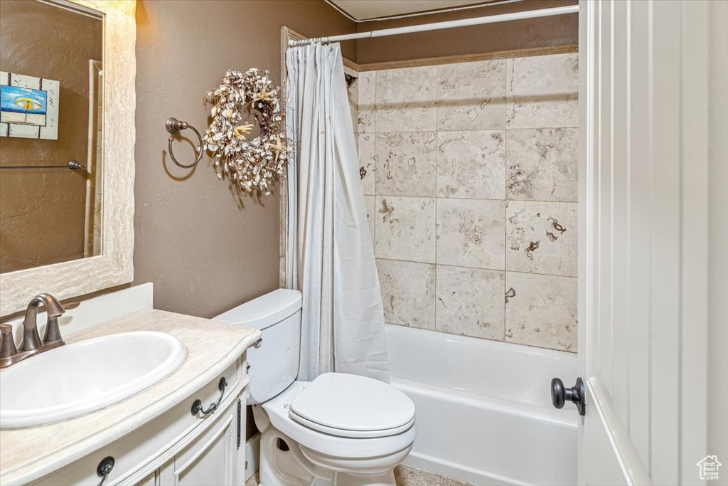 Full bathroom featuring shower / bathtub combination with curtain, vanity, and toilet