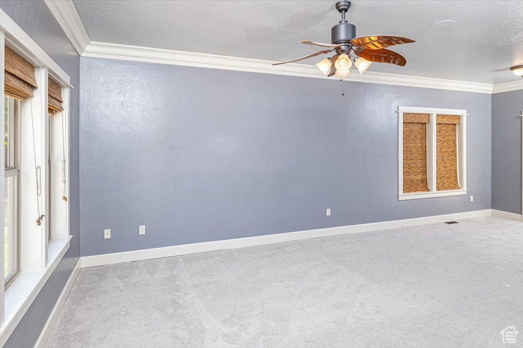 Spare room with ornamental molding, carpet, and ceiling fan