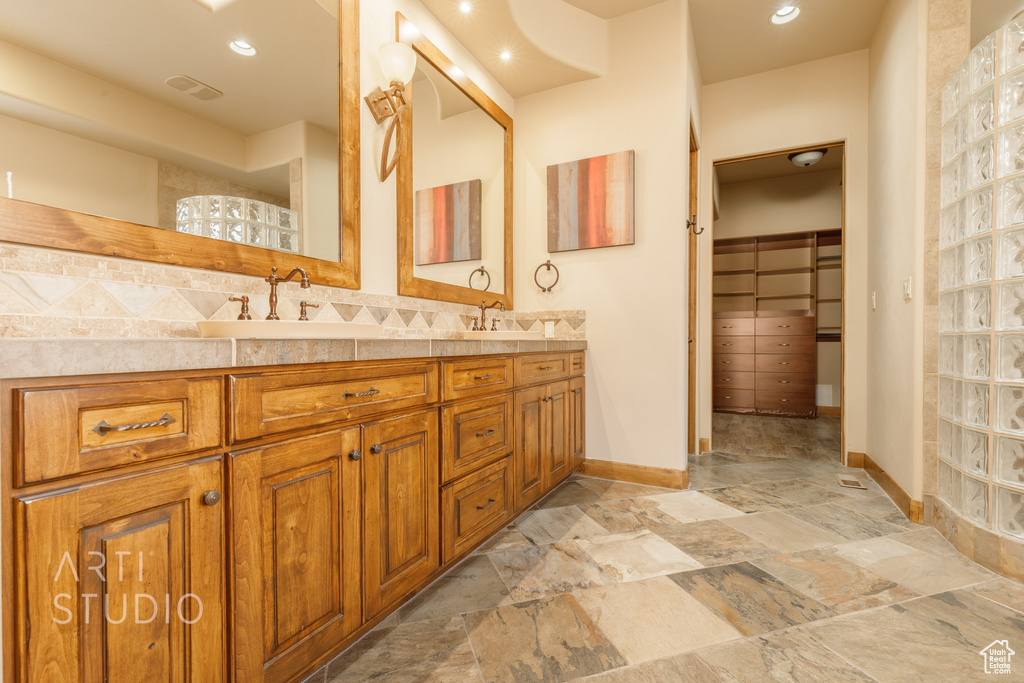 Bathroom featuring tasteful backsplash, dual vanity, and tile floors