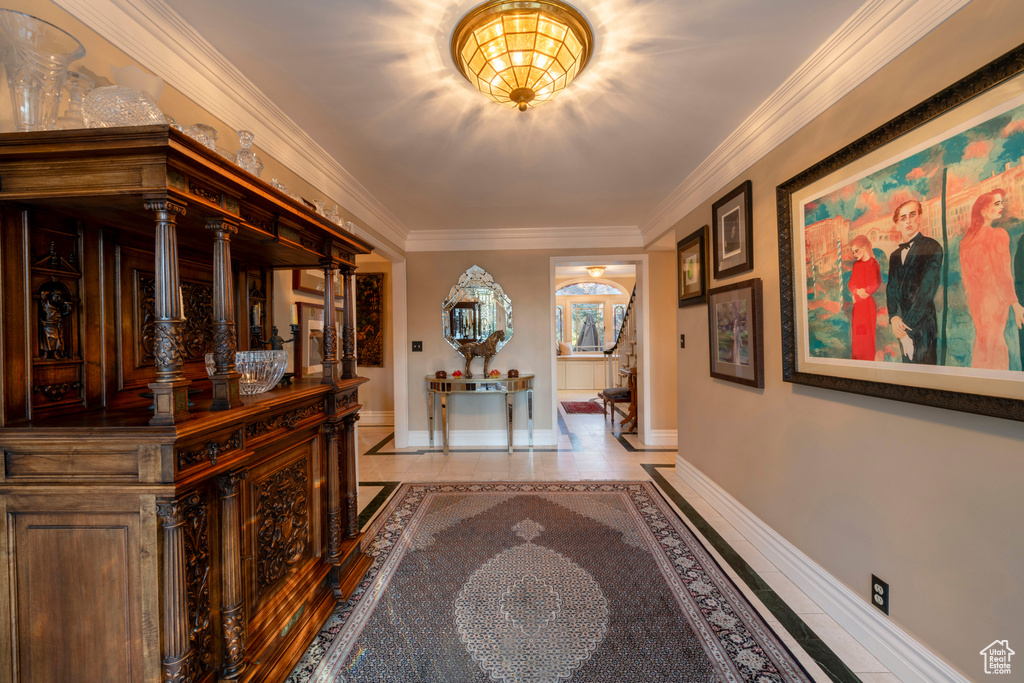 Hallway with light tile flooring and ornamental molding