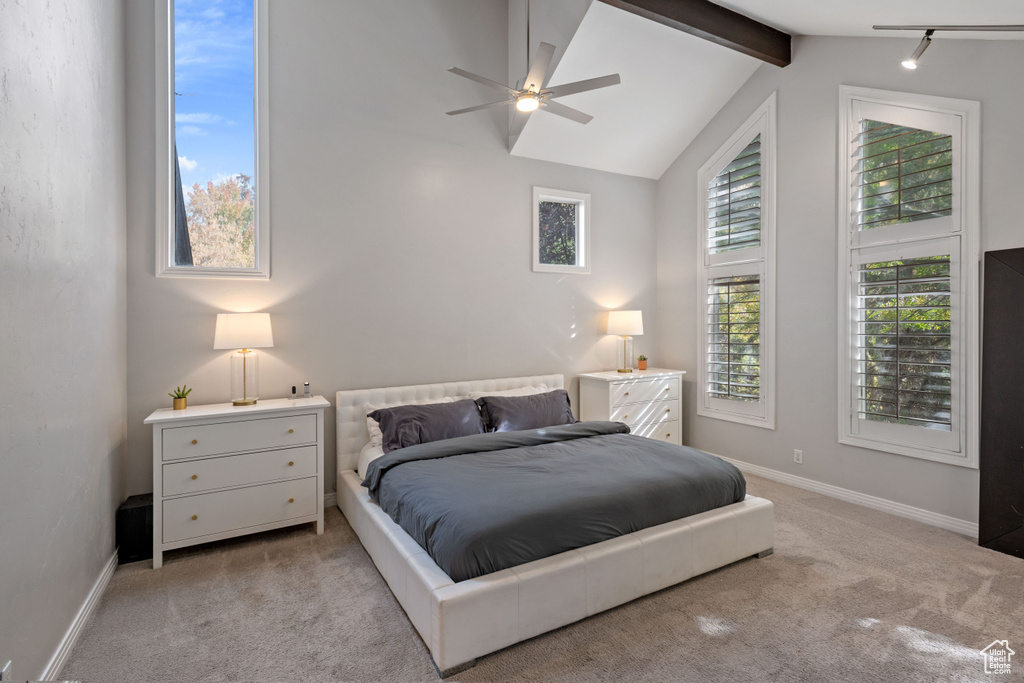 Bedroom with beam ceiling, ceiling fan, light colored carpet, and high vaulted ceiling