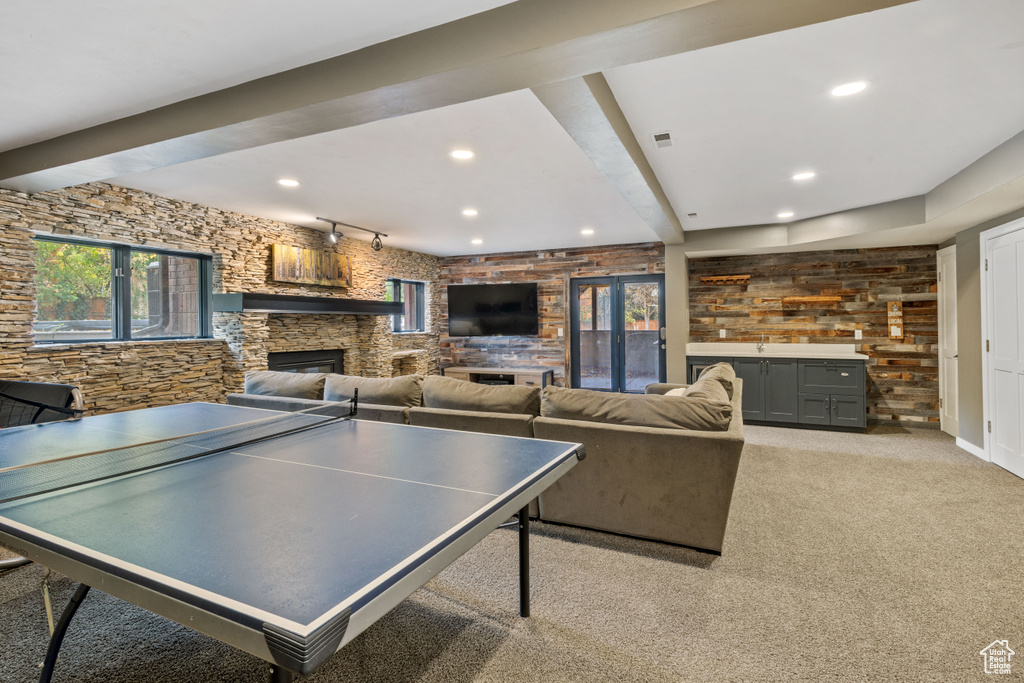 Game room featuring beamed ceiling, a fireplace, and light carpet