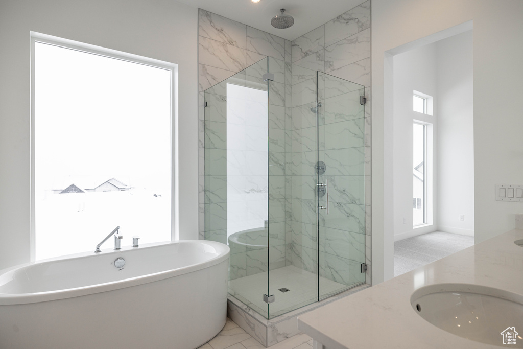 Bathroom with tile floors, sink, a wealth of natural light, and separate shower and tub