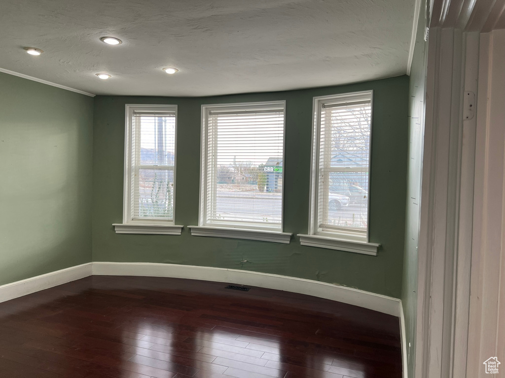 Spare room featuring crown molding and wood-type flooring