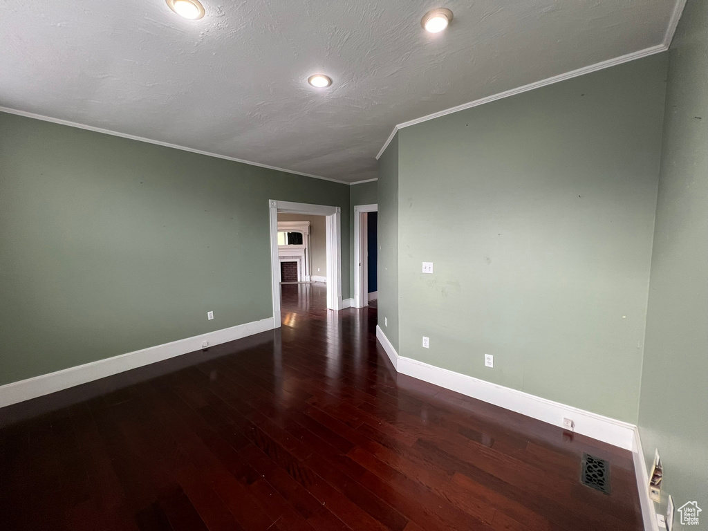 Spare room featuring dark hardwood / wood-style flooring and ornamental molding