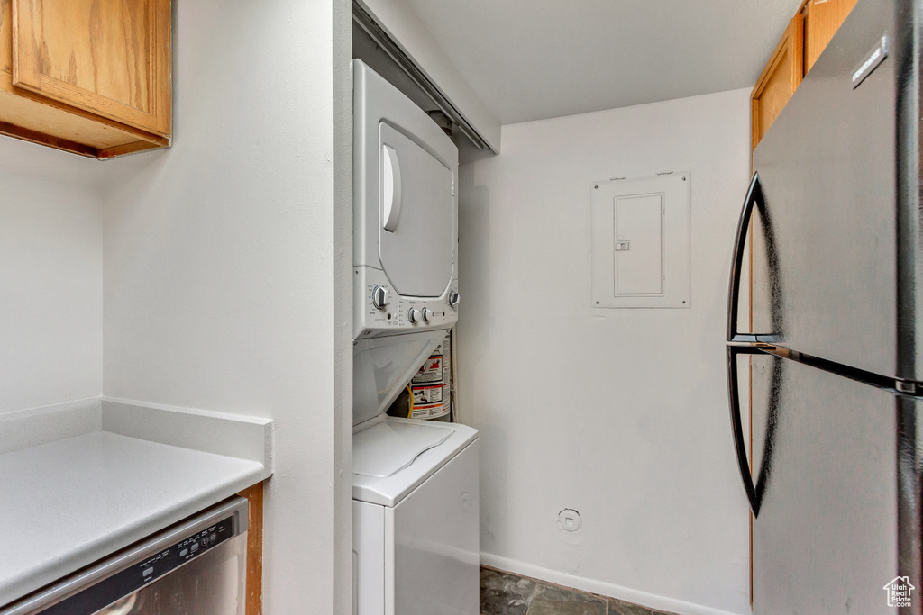 Laundry area featuring stacked washer and dryer and tile flooring