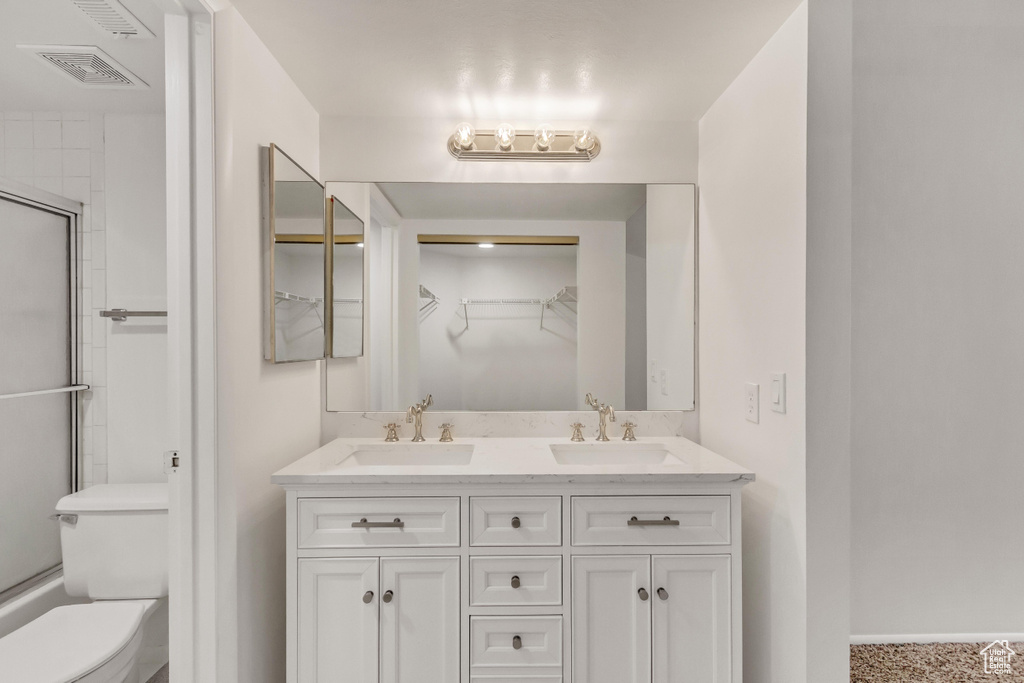 Bathroom with large vanity, double sink, and toilet