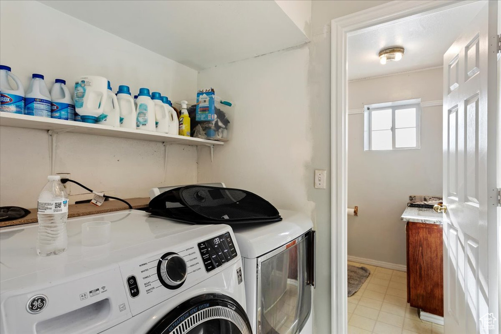 Clothes washing area featuring light tile flooring and independent washer and dryer