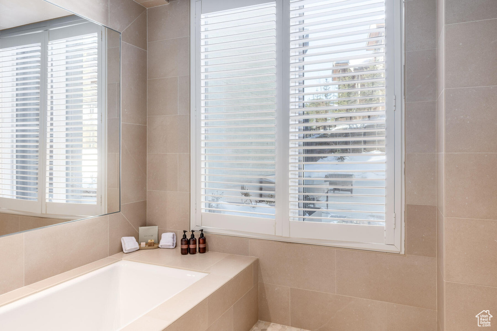 Bathroom featuring plenty of natural light and tiled tub