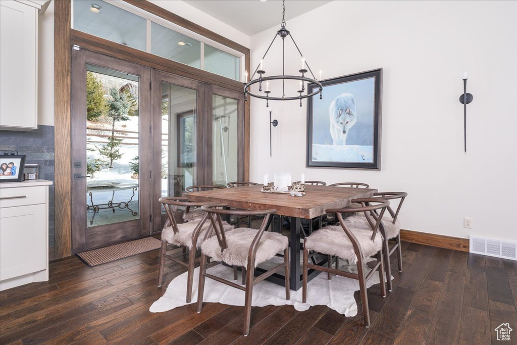 Dining area with an inviting chandelier and dark wood-type flooring