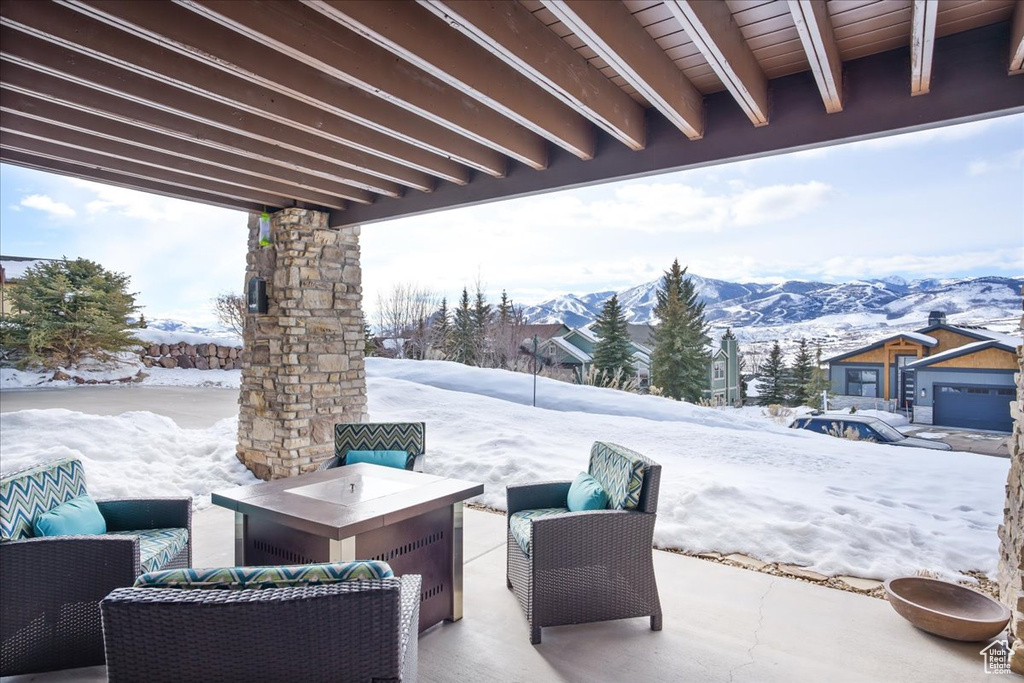 Snow covered patio with an outdoor living space and a mountain view