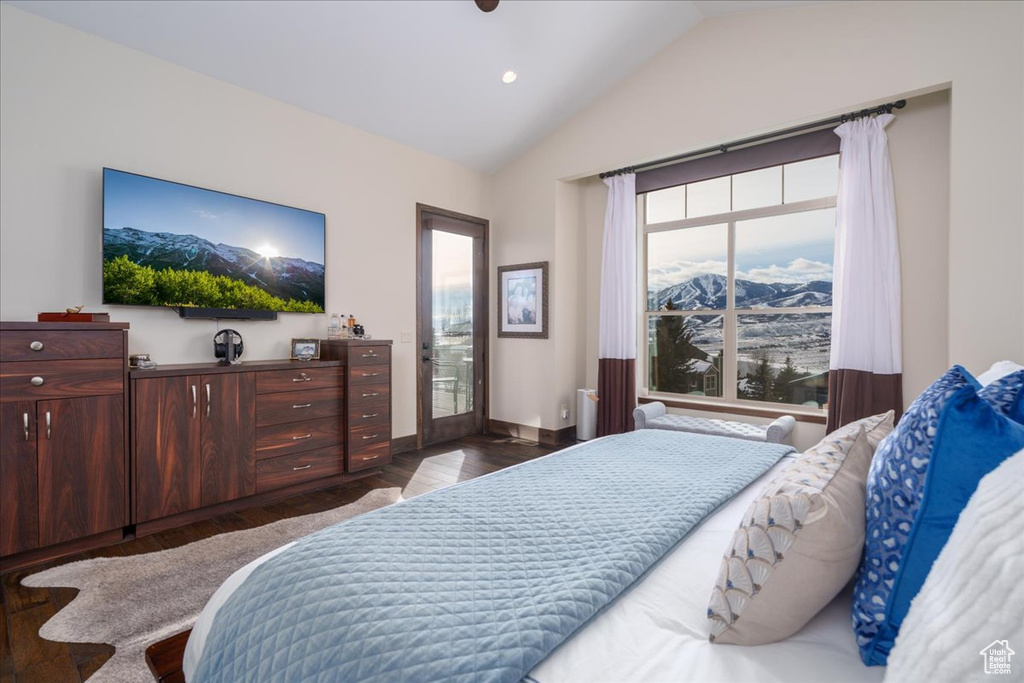 Bedroom featuring dark hardwood / wood-style flooring, vaulted ceiling, and a mountain view