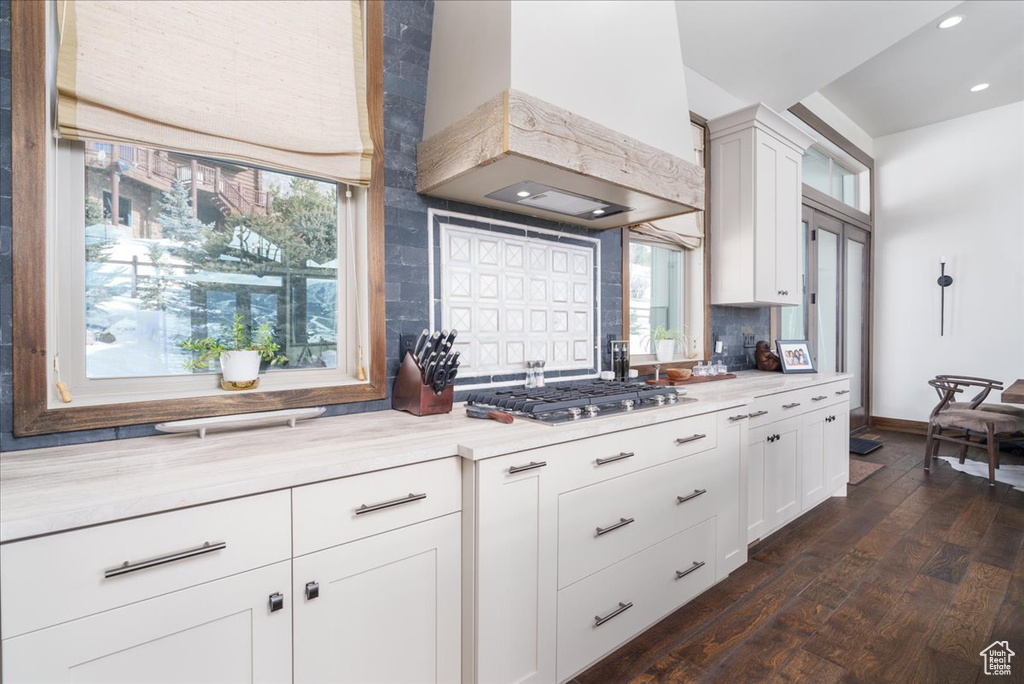 Kitchen featuring tasteful backsplash, white cabinetry, dark hardwood / wood-style flooring, and custom range hood
