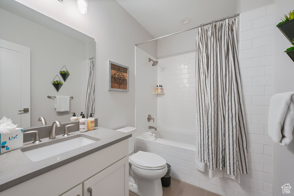 Full bathroom with vanity, tile floors, shower / bathtub combination with curtain, and toilet