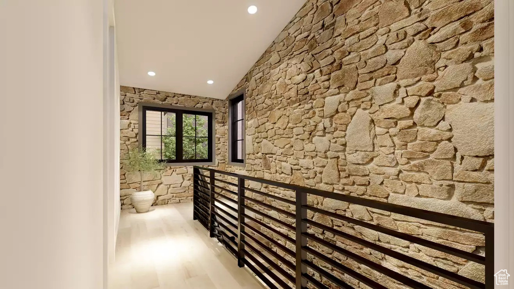 Hallway featuring light hardwood / wood-style floors and vaulted ceiling
