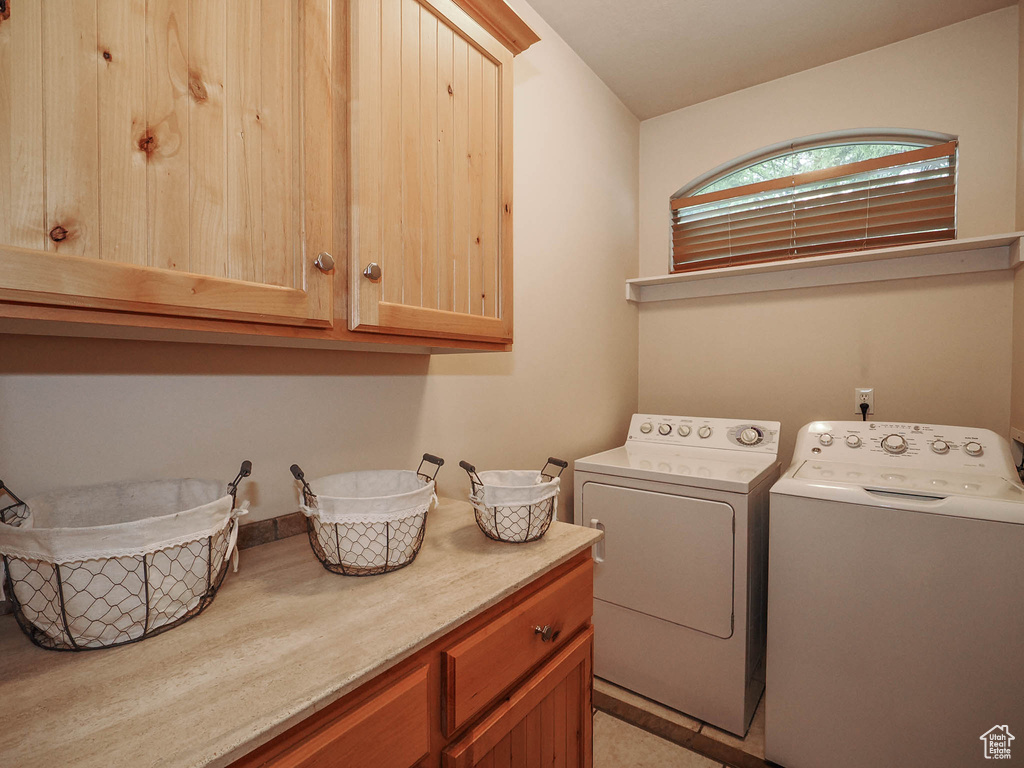 Washroom featuring washing machine and clothes dryer and cabinets