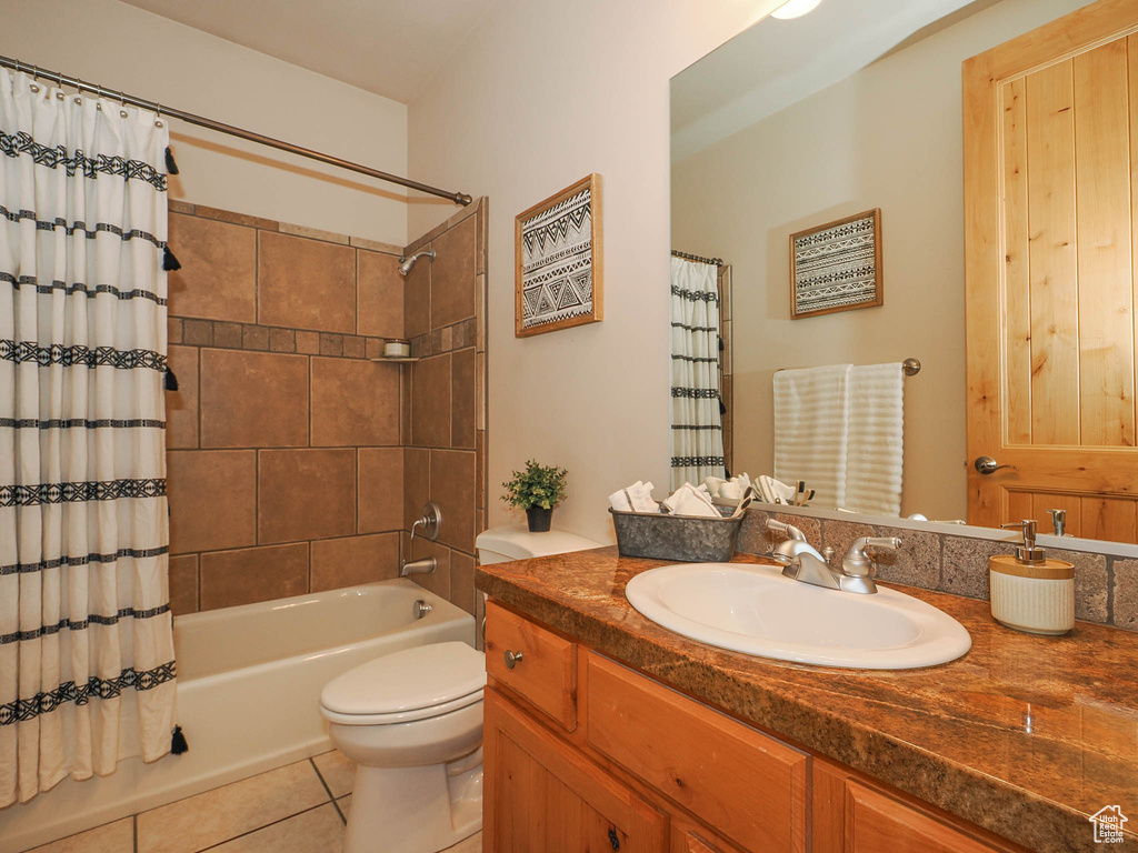 Full bathroom featuring shower / bathtub combination with curtain, toilet, oversized vanity, and tile flooring