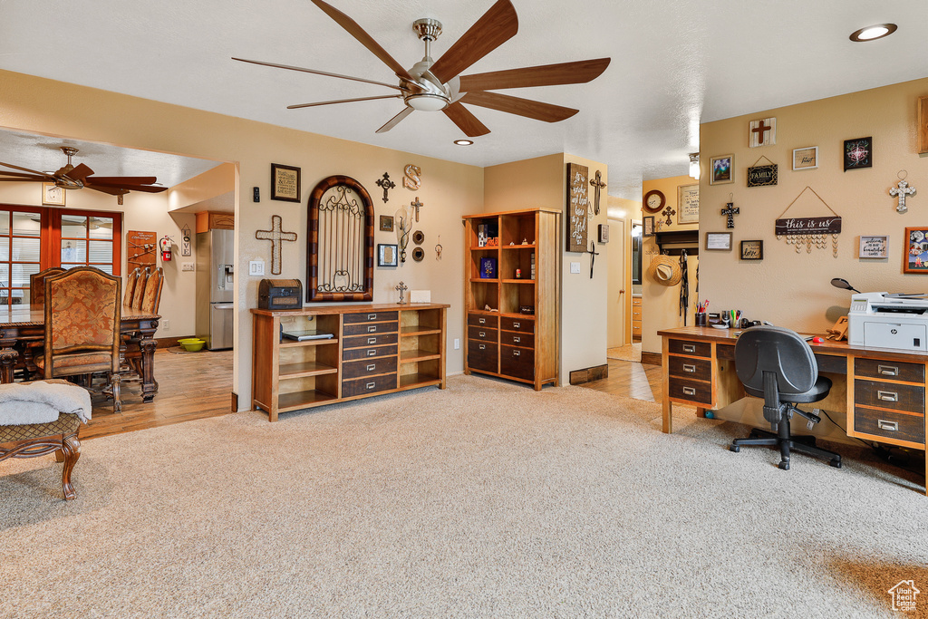 Home office featuring light colored carpet and ceiling fan
