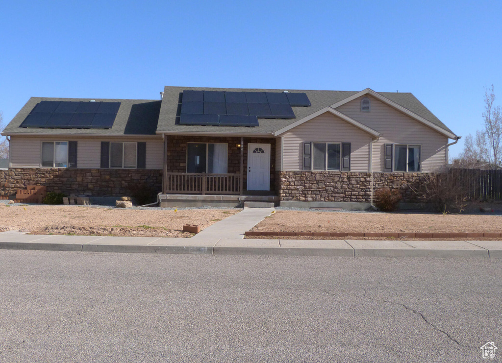 View of front of house featuring solar panels and a porch