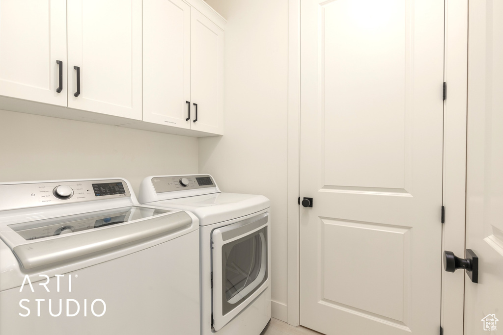 Laundry room with washer and dryer and cabinets