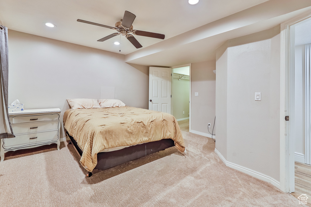 Carpeted bedroom with a closet, a spacious closet, and ceiling fan