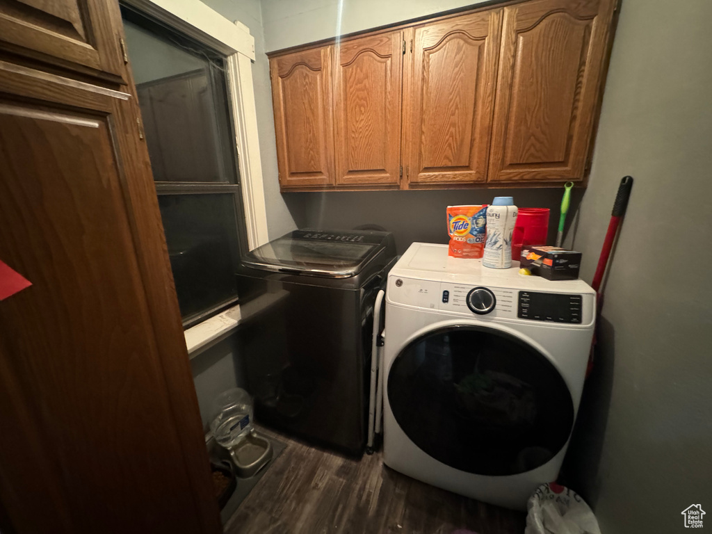 Laundry room with cabinets, dark hardwood / wood-style floors, and washing machine and dryer