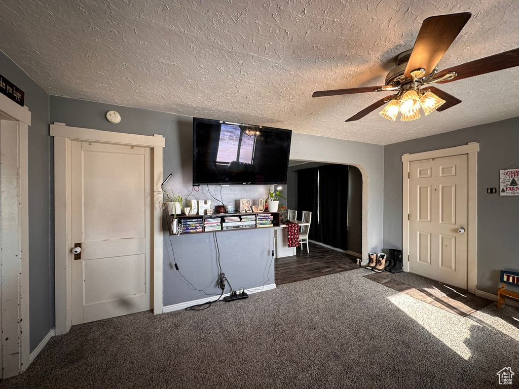 Kitchen with ceiling fan, dark carpet, and a textured ceiling