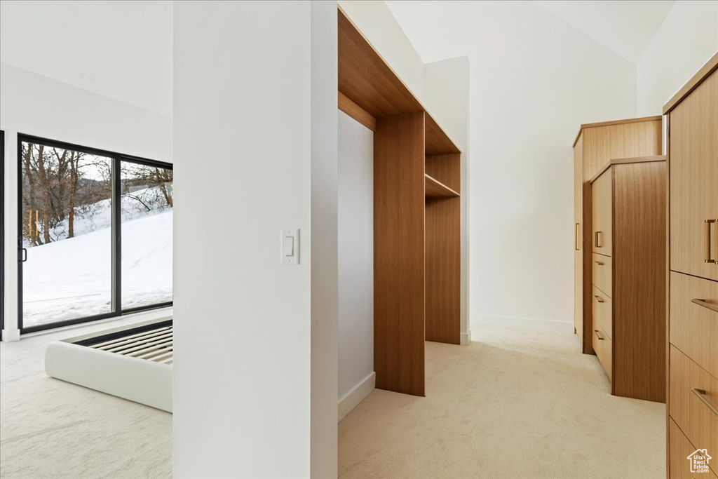 Walk in closet featuring lofted ceiling and light carpet